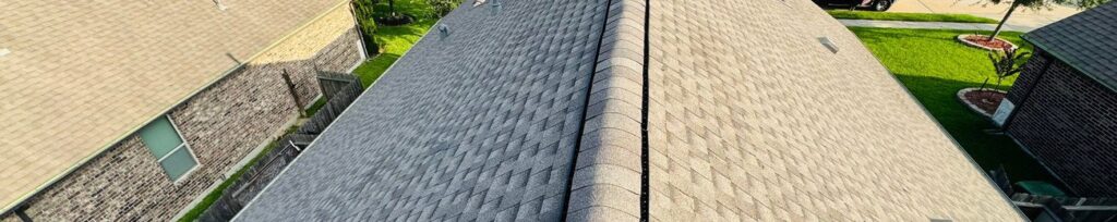 Aerial view along a newly shingled roof ridge in a suburban Houston neighborhood