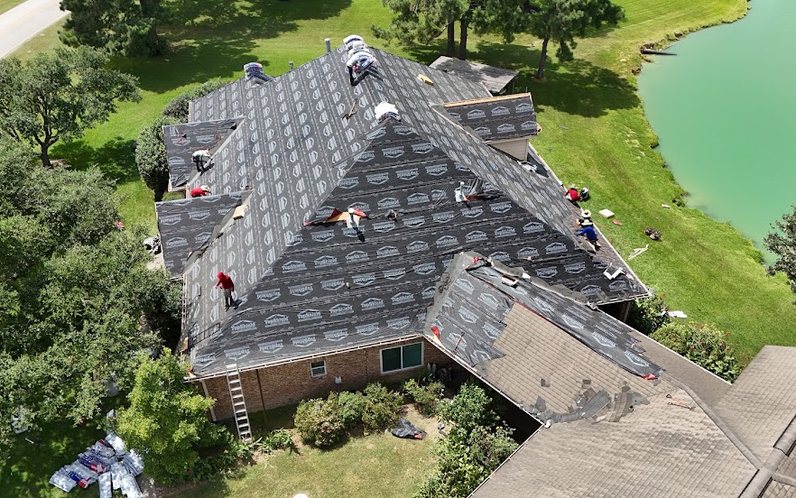 Drone view of the Texas Storm Pro crew replacing the roof on a lakeside Houston-area home