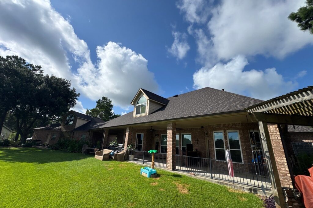 Texas home exterior showing a new shingle roof with seamless gutters along the porch