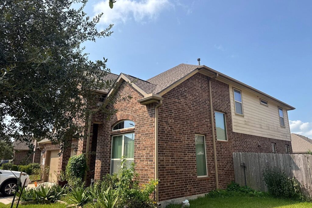 Two-story brick home in Pearland after its hail roof replacement