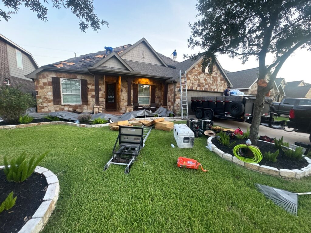 Roof replacement underway on a Houston home with roofing materials staged in the front yard